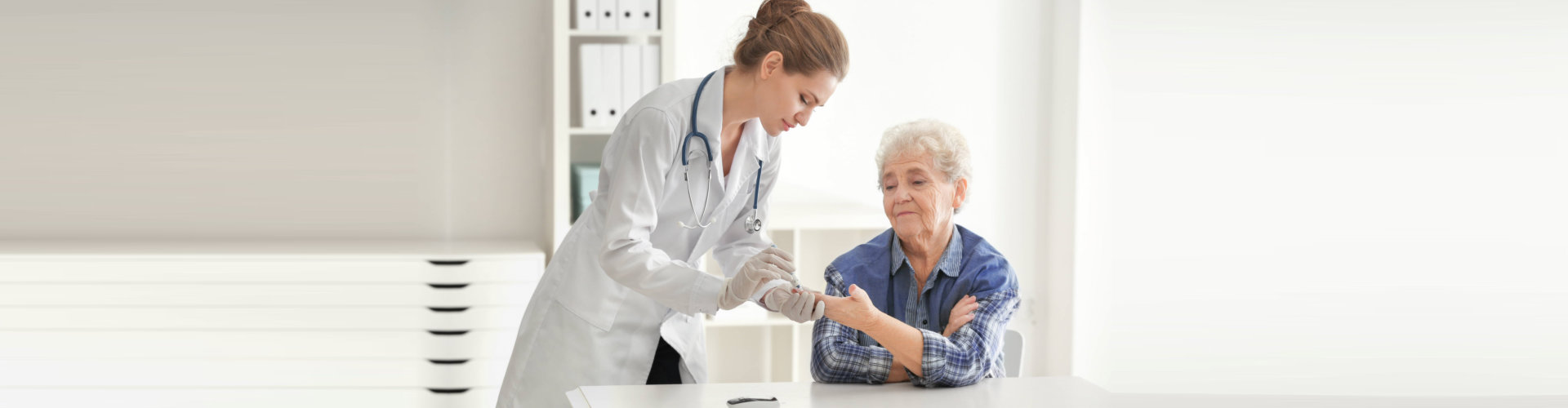 doctor checking senior woman's blood sugar